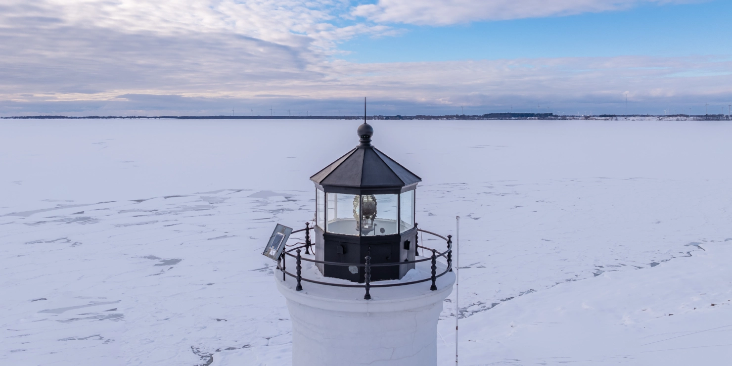 Lighthouse surrounded by frozen sea